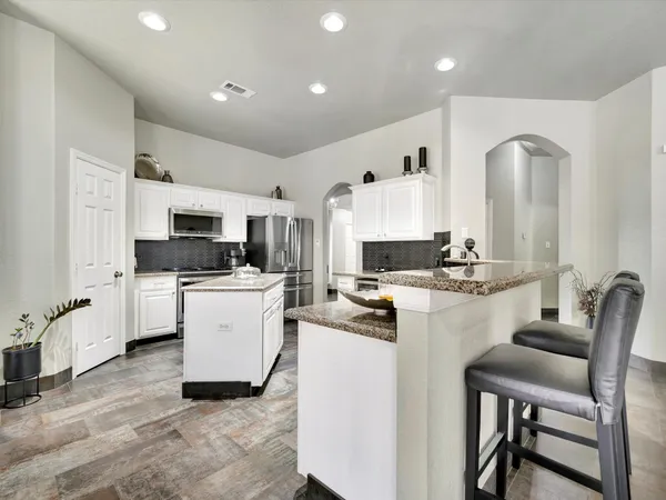 a kitchen with white cabinets and stainless steel appliances