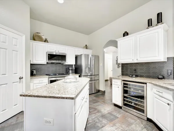 a kitchen with granite countertop a sink stove and refrigerator