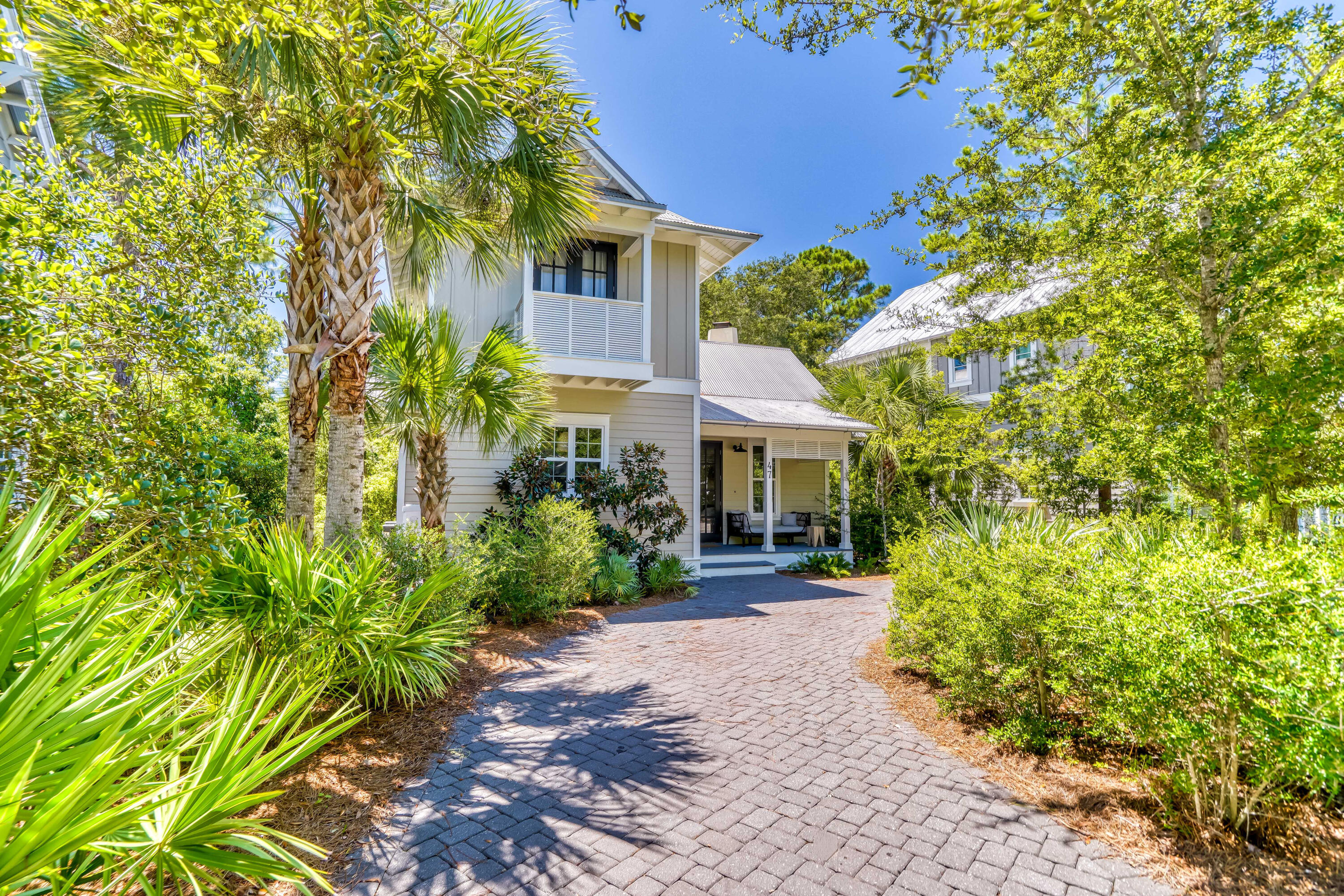 a front view of a house with a yard and potted plants