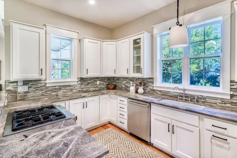 a kitchen with a stove a sink and a window