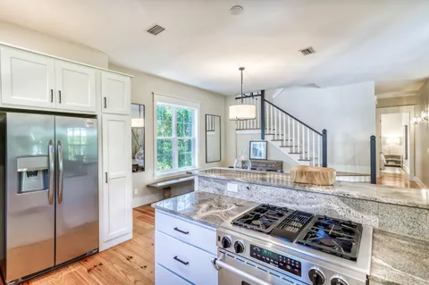 a kitchen with stainless steel appliances granite countertop a stove a refrigerator and a granite counter tops with wooden floors