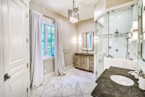 a bathroom with a granite countertop shower sink and mirror