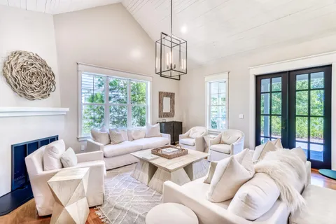 a living room with furniture fireplace and a large window