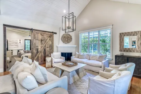 a living room with furniture a fireplace and a large window