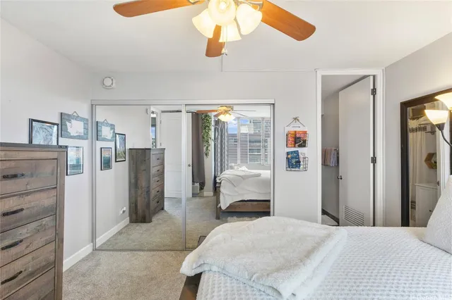 a bedroom with a bed dresser and white cabinets