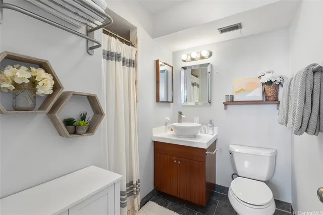 a bathroom with a toilet sink vanity tub and mirror
