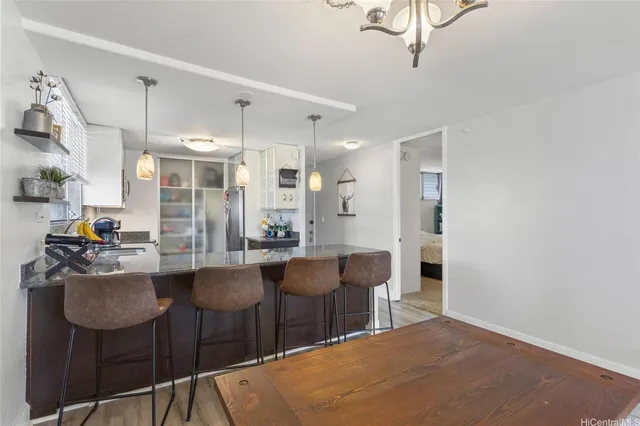 a kitchen with stainless steel appliances kitchen island granite countertop a dining table chairs and granite counter tops