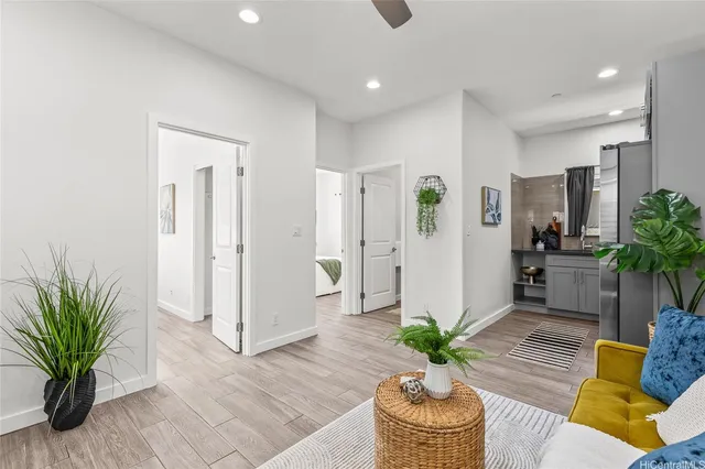 a living room with furniture potted plant and a wooden floor