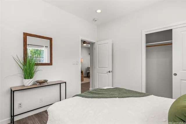 a bedroom with a bed and a potted plant