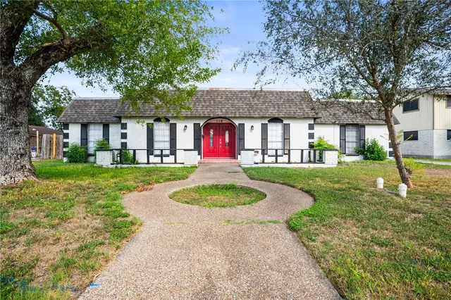 a front view of a house with yard and green space