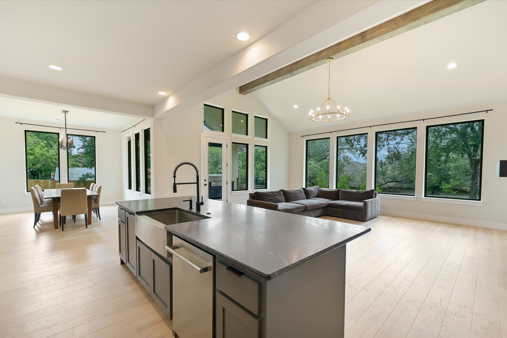 913 Presa Arriba Road Austin, TX 78733 - Photo 8 of 30 An open-concept living space boasts high ceilings, abundant natural light, and seamless flow from kitchen to dining.