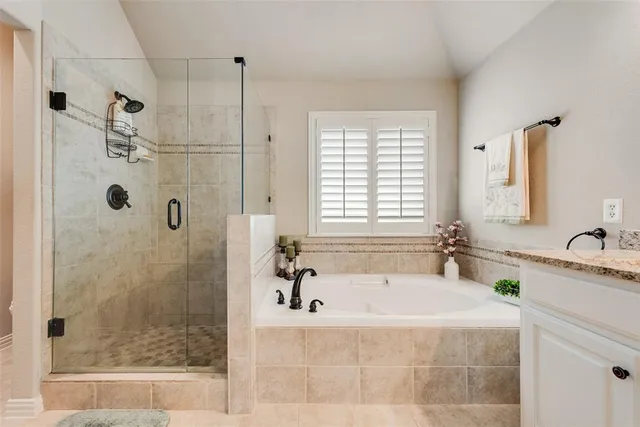 a spacious bathroom with sink shower and a bathtub