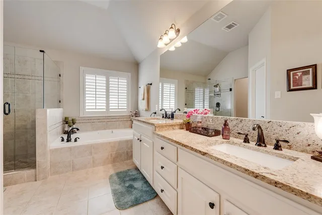 a spacious bathroom with a granite countertop tub sink and mirror