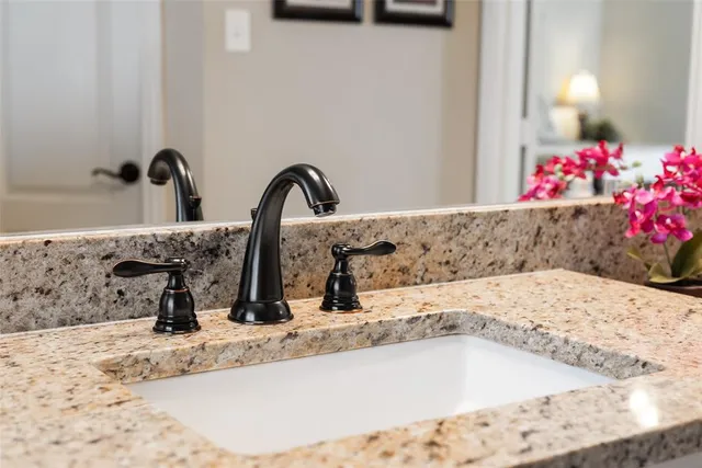 a bathroom with a granite countertop sink and a mirror