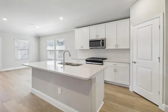 a kitchen with stainless steel appliances a sink stove and cabinets