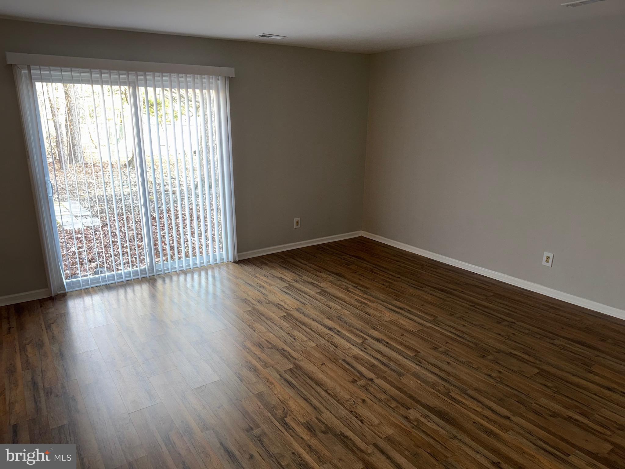 26 Hampton Gate Drive, Unit B Sicklerville, NJ 08081 - Photo 5 of 17 a view of an empty room with wooden floor and a window