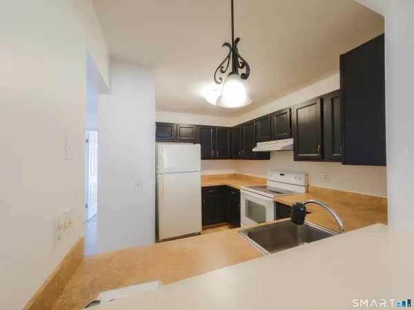 a view of a kitchen with a sink and refrigerator