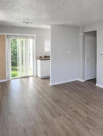 a view of a kitchen with wooden floor and a window