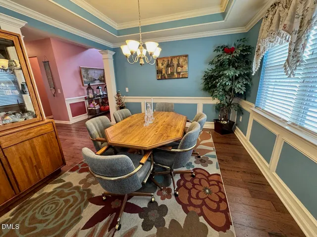 a view of a dining room with furniture wooden floor and chandelier