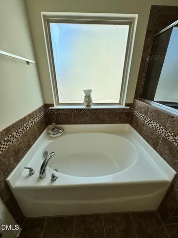 a bath tub sitting in a bathroom next to a window