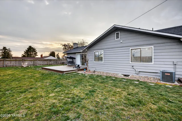 a view of a house with a yard and wooden fence