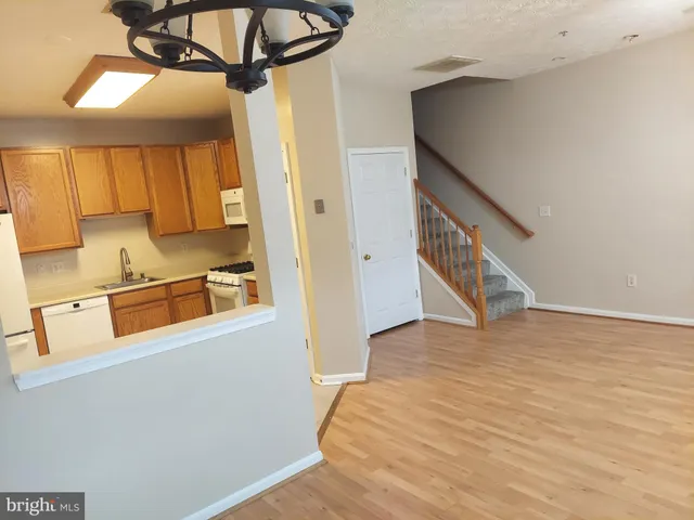 a view of a kitchen with wooden floor and cabinets