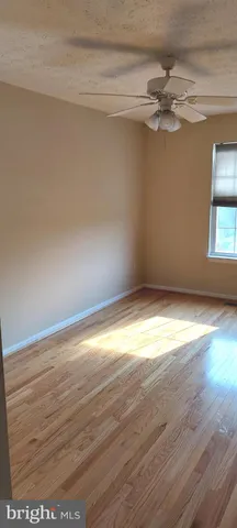 a view of a room with wooden floor and fan