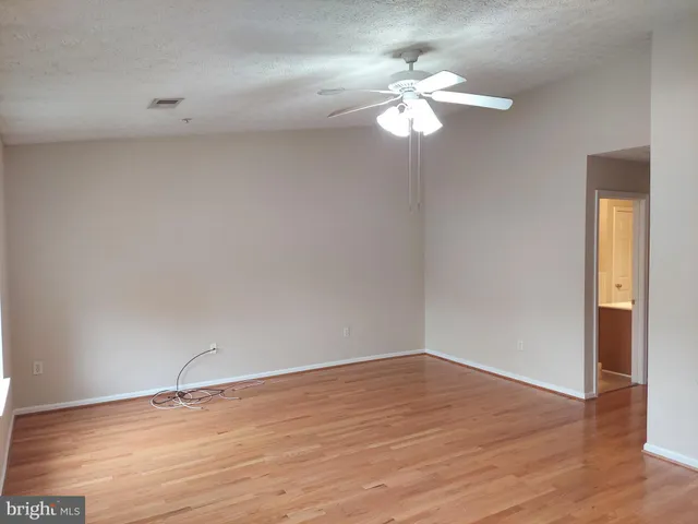 a view of a room with wooden floor and fan