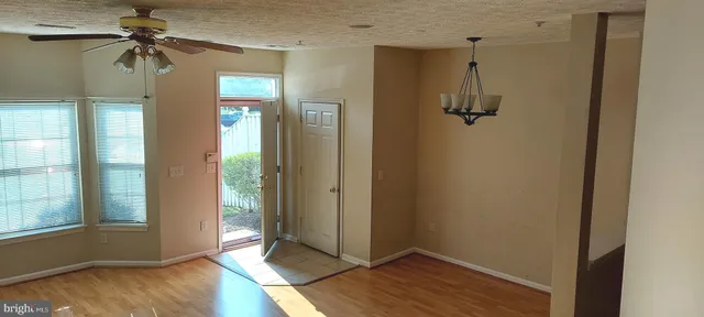 a view of a hallway with a chandelier fan and windows