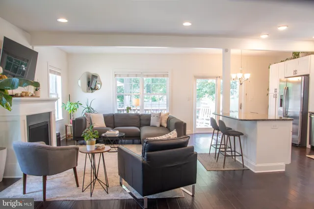 a living room with furniture a fireplace and a large window