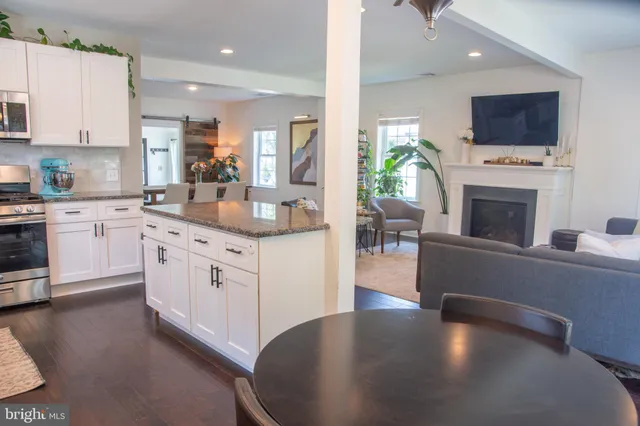 a kitchen with stainless steel appliances granite countertop a stove top oven a sink dishwasher and a microwave with wooden floor