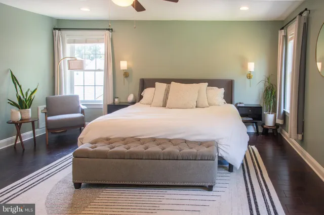 a large white bed in a room next to a window