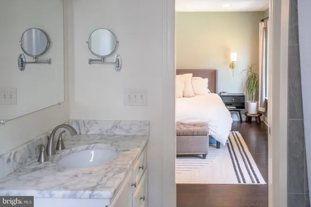 a en suite bathroom with a granite countertop sink and a mirror