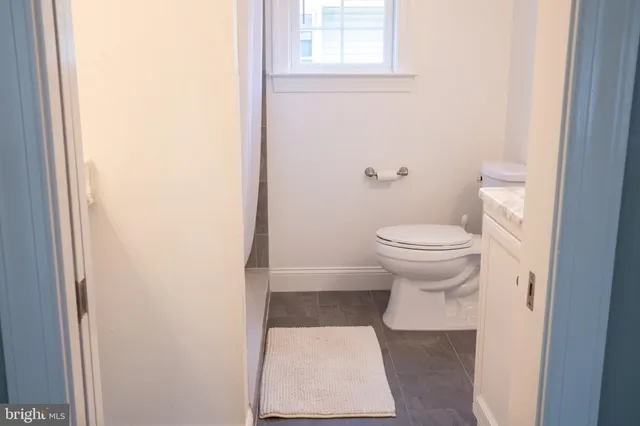 a bathroom with a toilet and a window