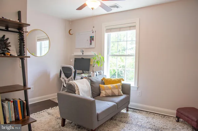 a living room with furniture and a mirror