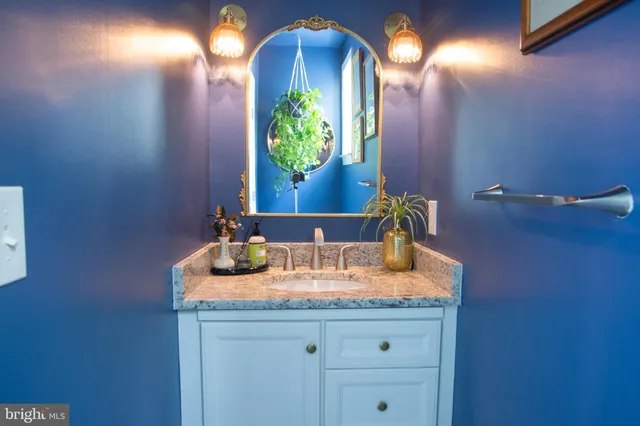 a bathroom with a granite countertop sink and a mirror