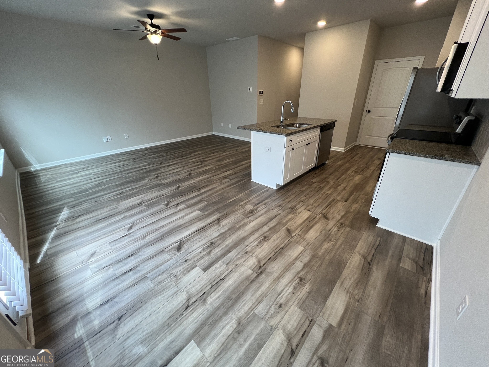 130 Skipjack Court Covington, GA 30016 - Photo 7 of 36 a view of a kitchen with flat screen tv and wooden floor