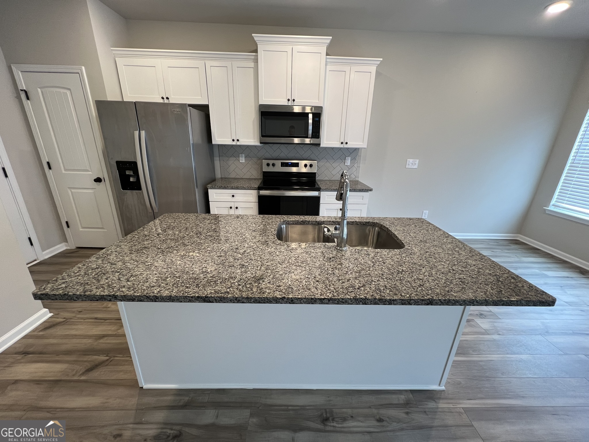 130 Skipjack Court Covington, GA 30016 - Photo 9 of 36 a kitchen with granite countertop a refrigerator and a sink