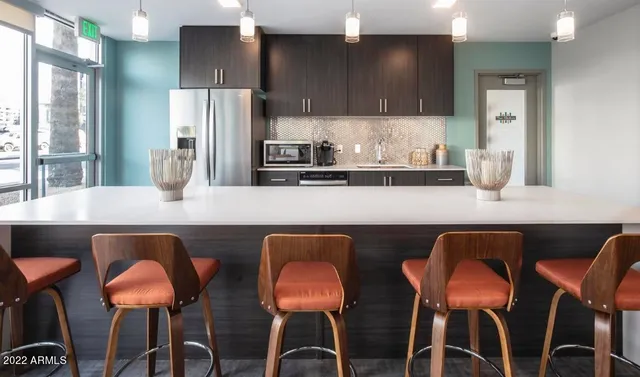 a kitchen with a dining table chairs cabinets and stainless steel appliances