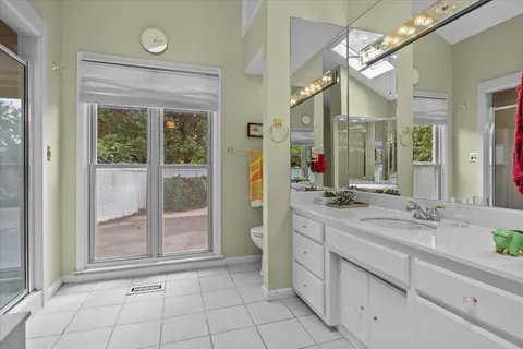 a spacious bathroom with a mirror a sink and a shower