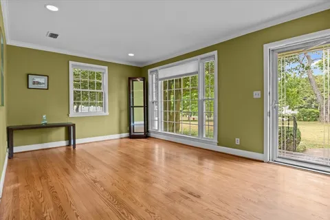 a view of an empty room with a window and wooden floor