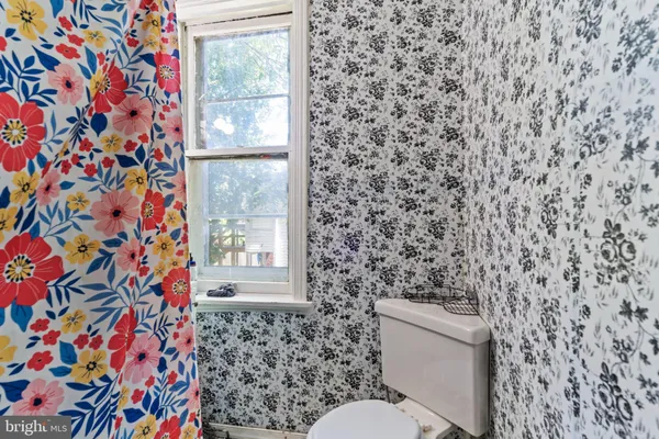 a bathroom with a toilet and a shower curtain