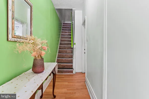a hallway with stairs and wooden floor