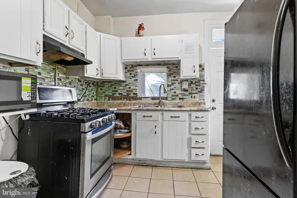 a kitchen with stainless steel appliances granite countertop a stove a refrigerator and a sink