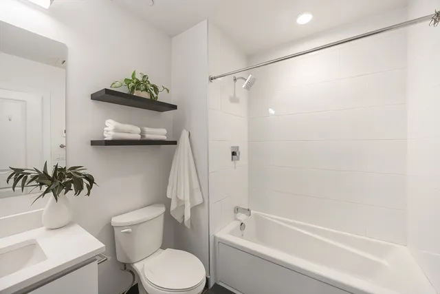a white toilet sitting next to a bath tub