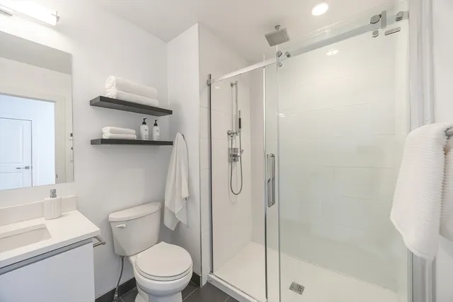 a bathroom with a shower a toilet and a sink