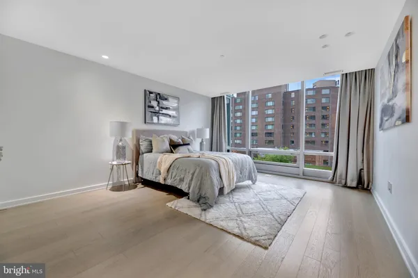 a spacious bedroom with a bed and a large window