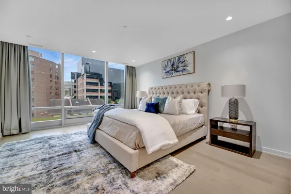 a bedroom with a bed lamp and a large window