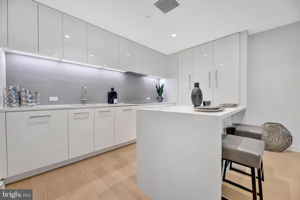a kitchen with cabinets a sink and chairs