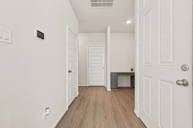 a view of empty room with wooden floor and window